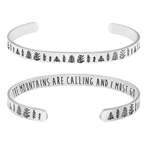 A silver cuff bracelet with mountain and a messages etched