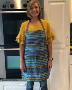 A woman wearing a colorful apron that's handmade in Guatemala