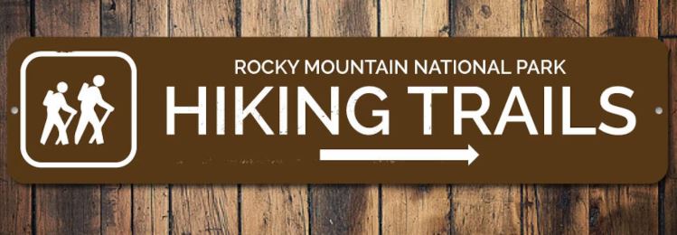 A wooden sign of a hiking trail