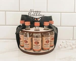 A tray shaped like a birthday cake with mini bottle of vodka